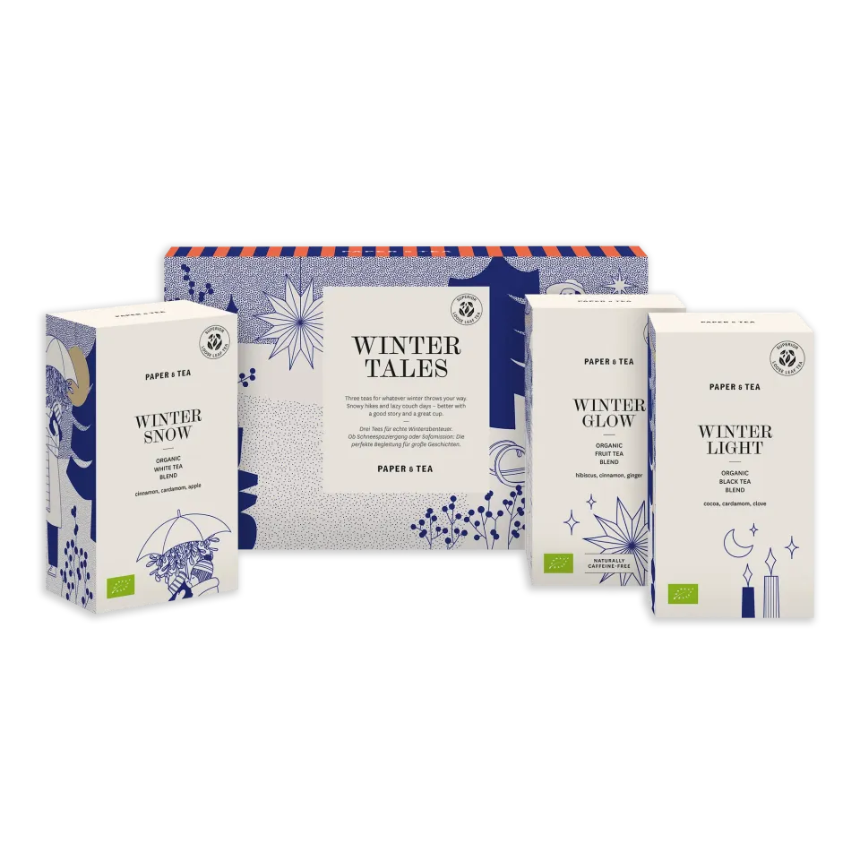 Vier stilvolle Winter-Tees von PAPER & TEA in weißen Verpackungen mit botanischen Designs.