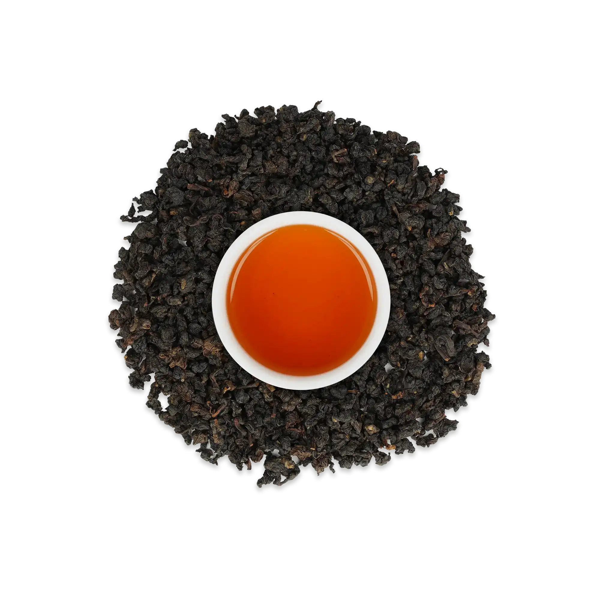 Weiße Keramiktasse mit bernsteinfarbenem Tee, umgeben von dunkel gerollten Teeblättern auf weißem Hintergrund.