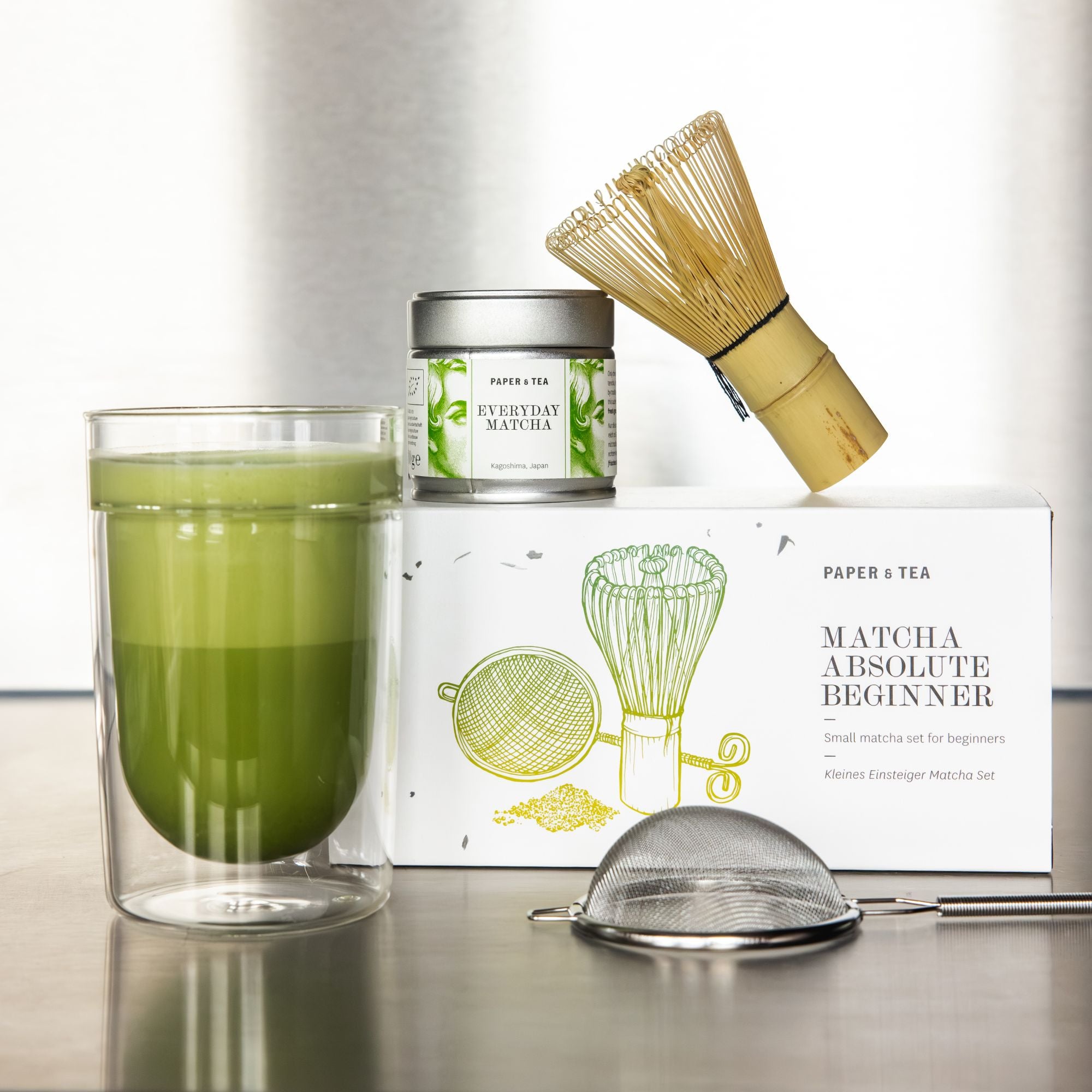 Elegantes Matcha-Set mit grünem Tee, doppelwandigem Glas, Bambusbesen, Metallsieb und P&T Dose.