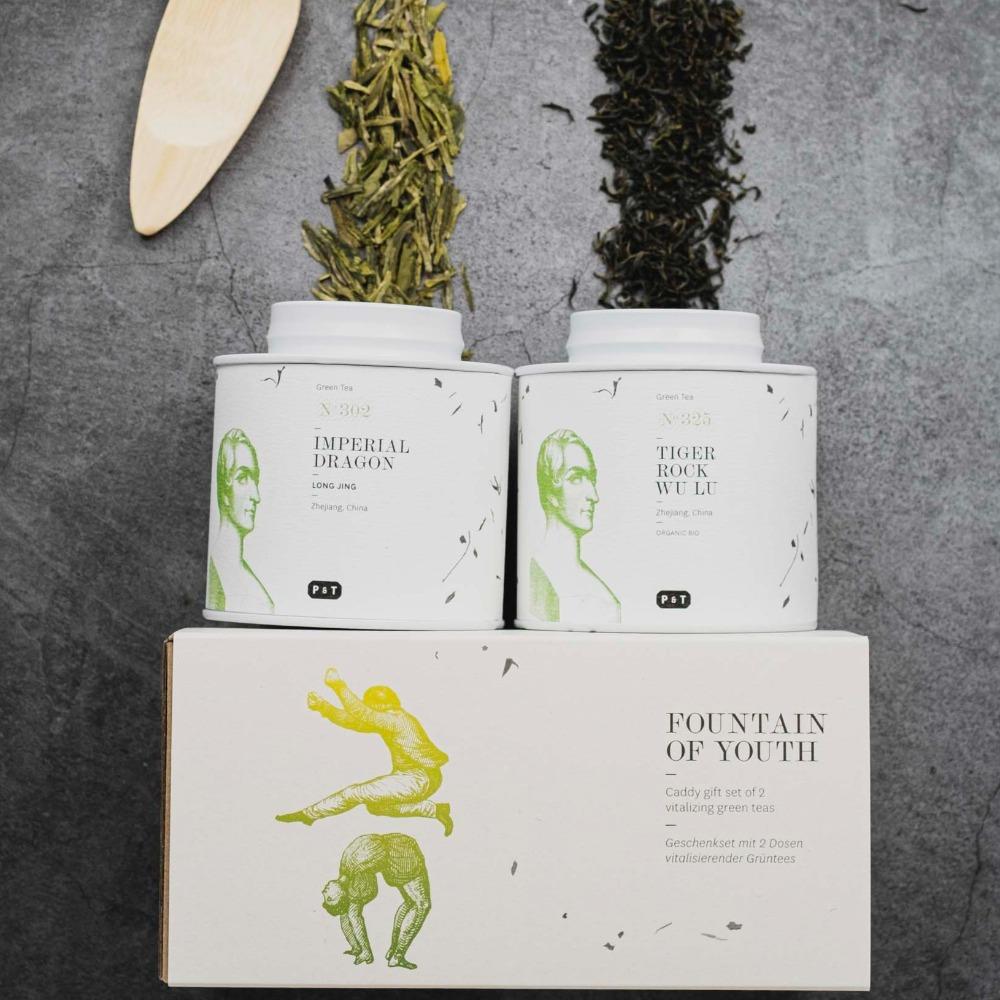 Geschenkset FOUNTAIN OF YOUTH mit zwei Teedosen, IMPERIAL DRAGON und TIGER ROCK, zeigt lose Grünteeblätter.