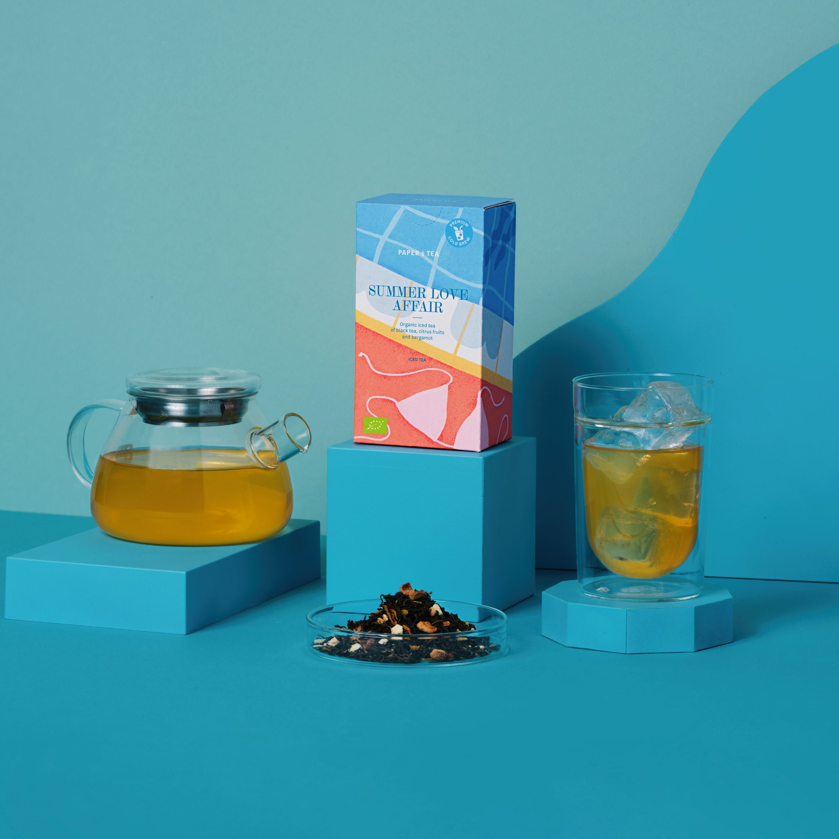 Eistee-Packaging 'Tea Summer Love Affair' mit klarem Teekännchen, Glas mit Eis und losem Schwarztee, Zitrus und Bergamotte.