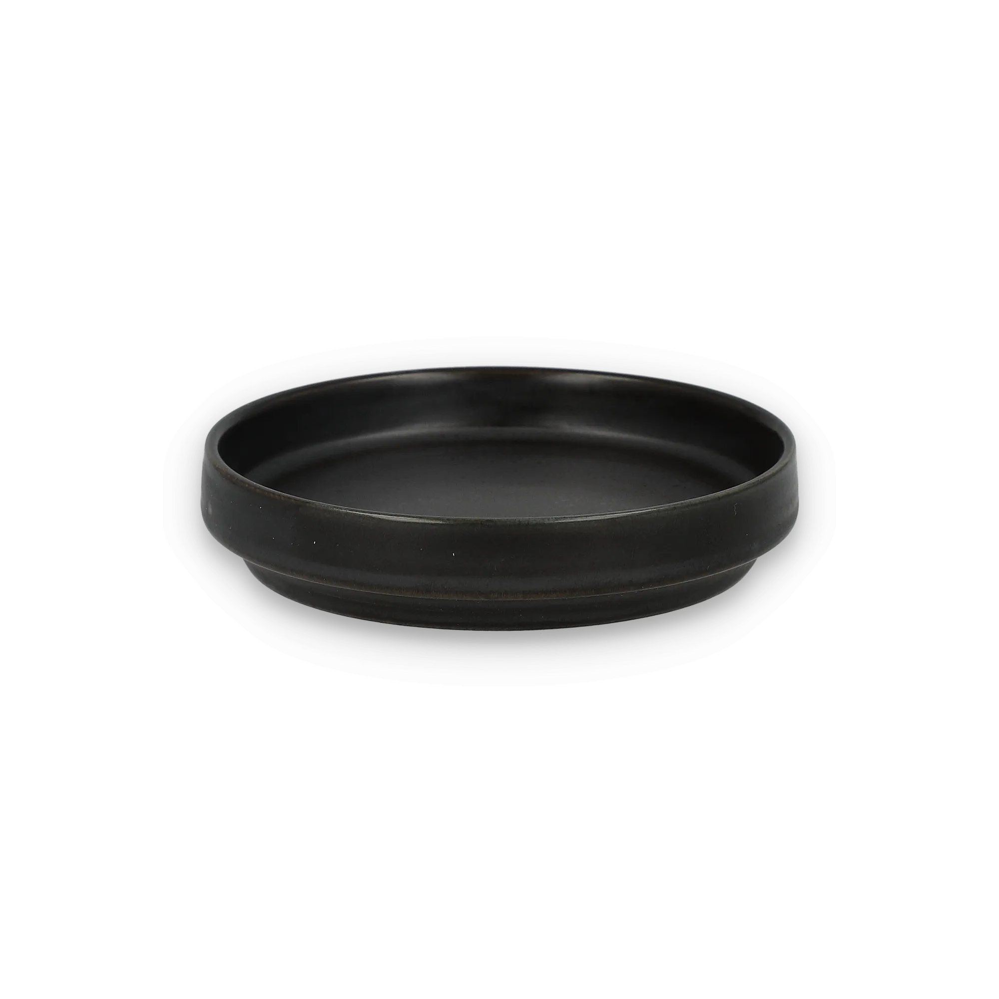 Schwarzer, runder Keramikteller mit matter Oberfläche und leichtem Rand vor schwarzem Hintergrund.