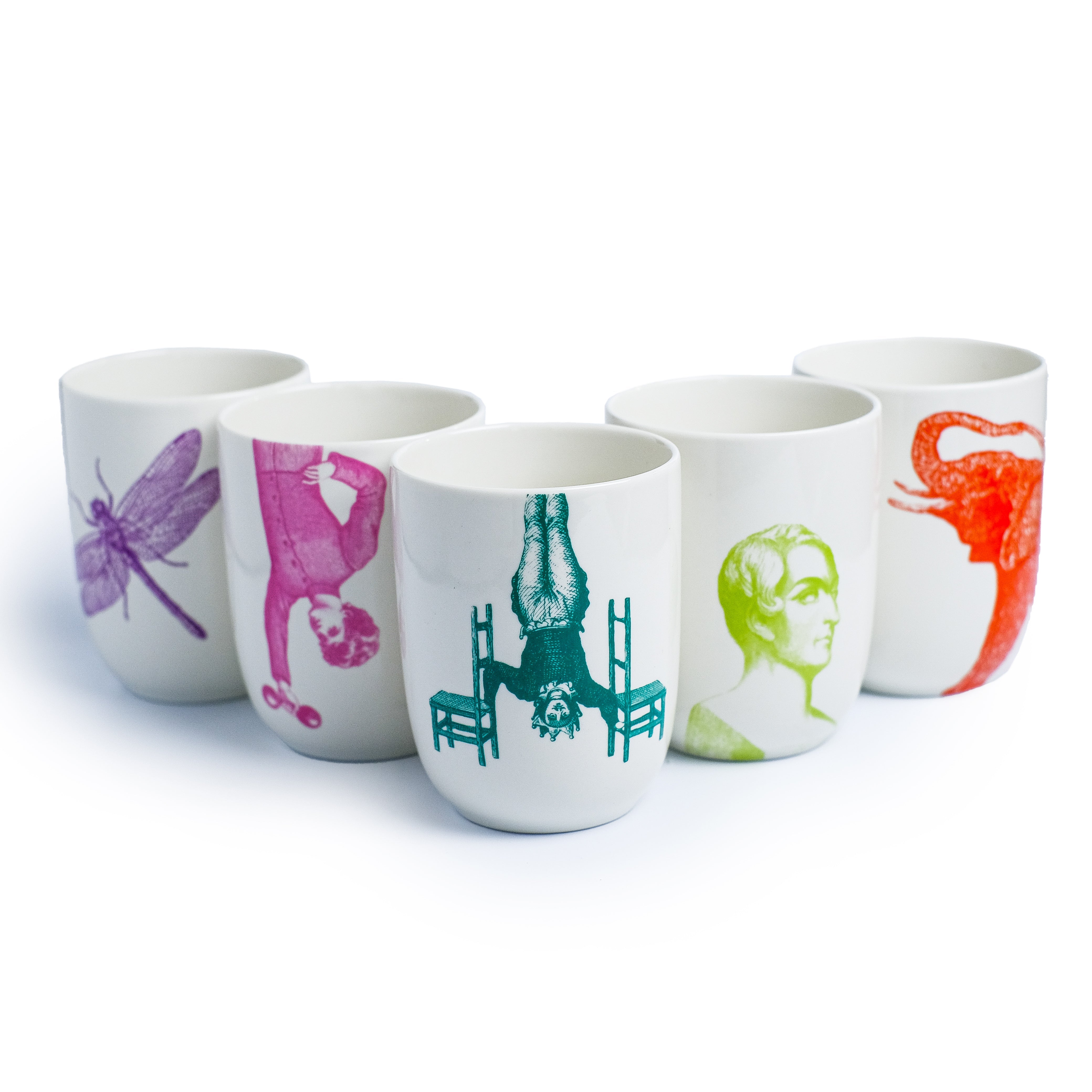 Weiße Keramiktassen mit bunten Illustrationen wie einer lila Libelle und einem orangefarbenen Elefantenkopf.