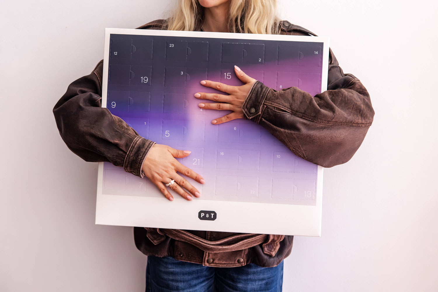 Frau hält Adventskalender in ihren Armen fest