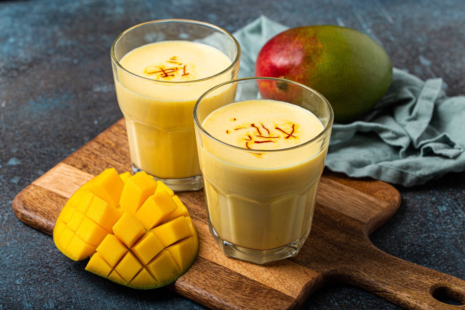 Zwei Gläser Mango Lassi mit Safran und frische Mango