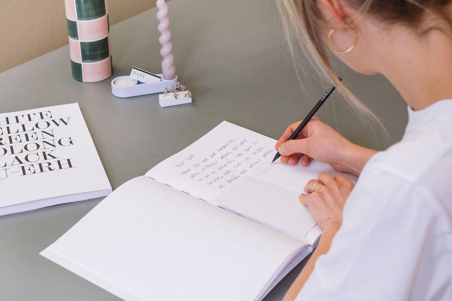 Frau schreibt in ihr Journal von PAPER & TEA