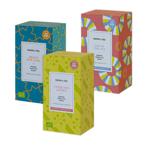 Drei farbenfrohe P&T Teeboxen: Blau mit BRAVE NEW EARL schwarzem Bio-Tee, hellgrün mit UNTER DEN LINDEN Kräutertee, pink mit TOP OF THE DAY Kräutertee.