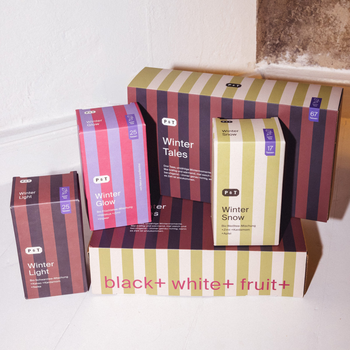 Vier bunte, gestreifte P&T Wintertee-Packungen mit Bio-Zutaten.