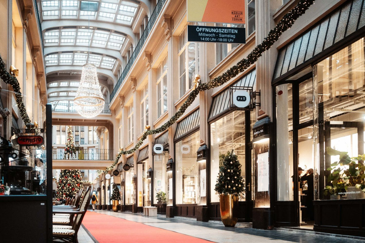 Elegante Einkaufspassage mit Glasdach, festlicher Weihnachtsdekoration und P&T Teegeschäft