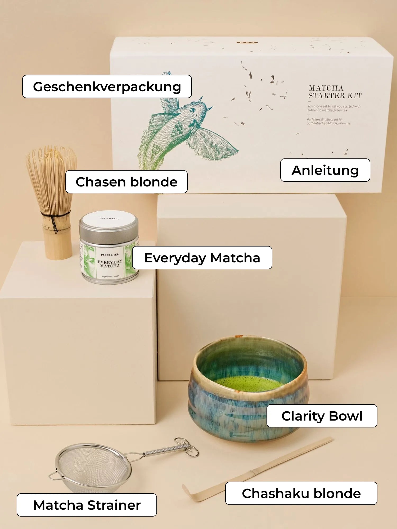 Matcha Starter Kit von PAPER & TEA mit Teedose, Bambusbesen, Keramikschale und Zubehör vor beigem Hintergrund.